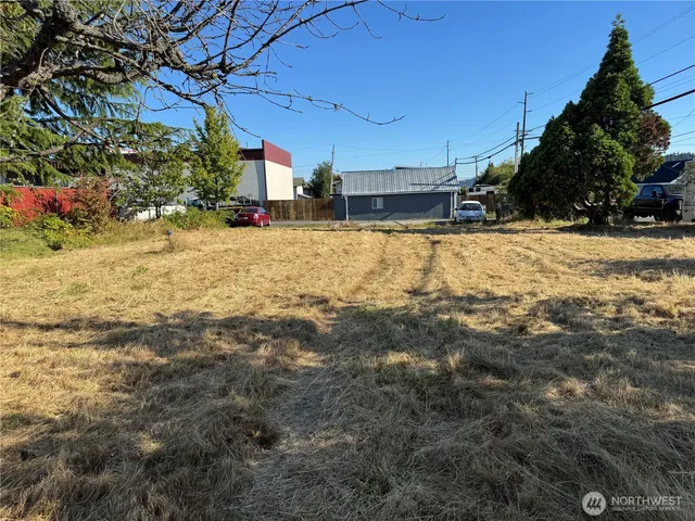 a view of a yard with wooden fence