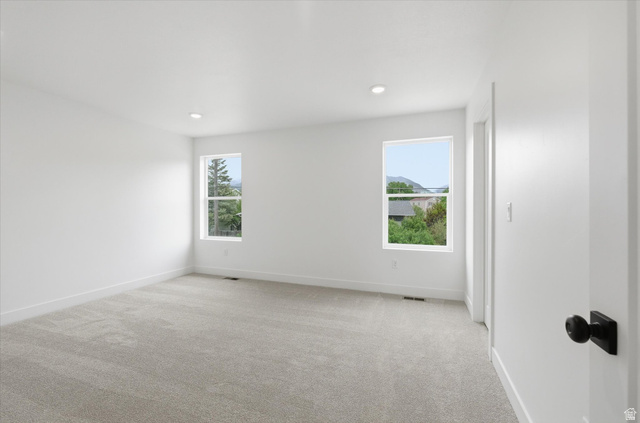 844 North 400 West Logan, UT 84321 - Photo 19 of 43 Bright room featuring two windows, recessed lighting, neutral carpeting, and white walls
