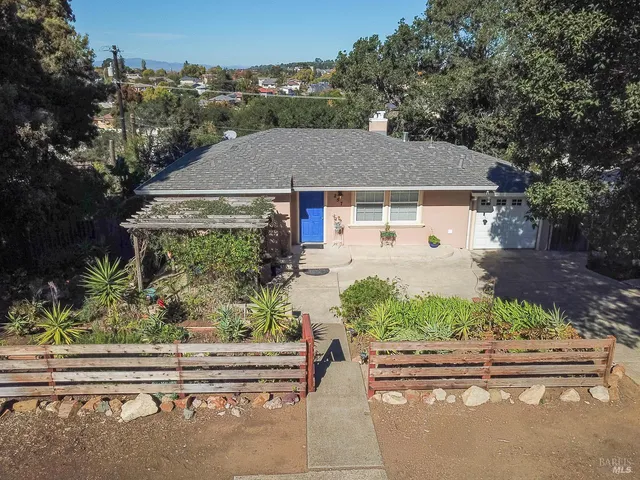 front view of house with a yard and potted plants
