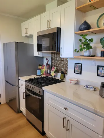 a kitchen with stainless steel appliances a stove a microwave and sink