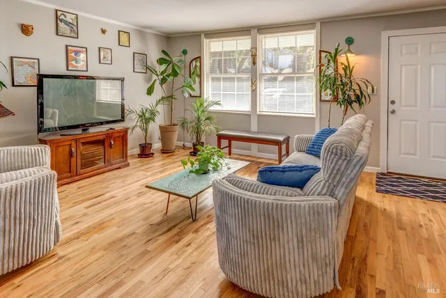 a living room with furniture a flat screen tv and a floor to ceiling window