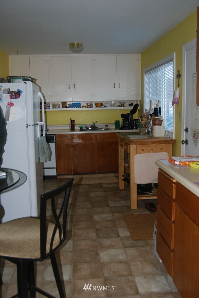 859 Edmonds Avenue Northeast Renton, WA 98056 - Photo 17 of 22 a kitchen with a table chairs and a refrigerator
