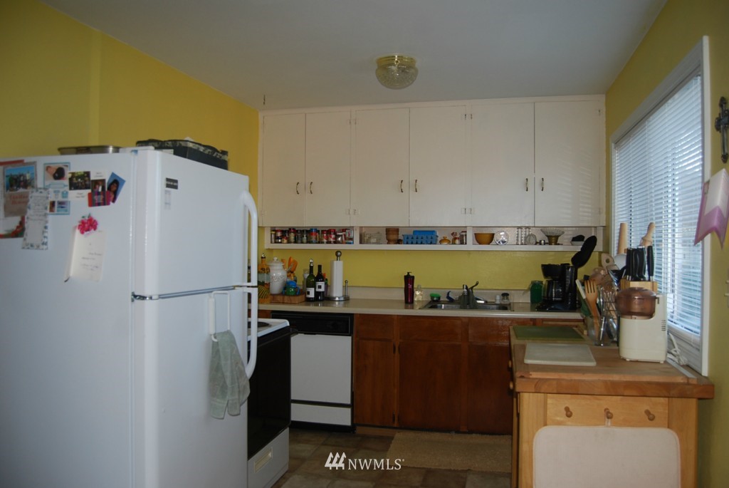 859 Edmonds Avenue Northeast Renton, WA 98056 - Photo 18 of 22 a white refrigerator freezer sitting inside of a kitchen