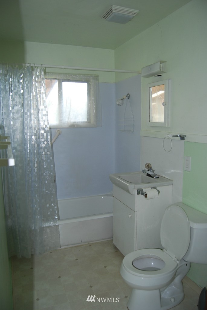 859 Edmonds Avenue Northeast Renton, WA 98056 - Photo 5 of 22 a white toilet sitting next to a bathroom sink and shower