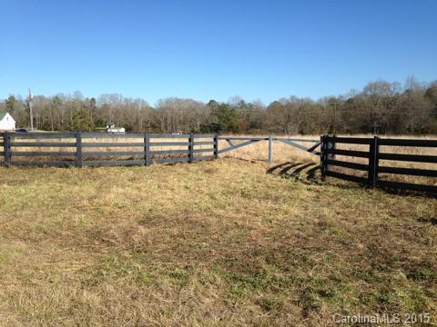 a view of a yard with wooden fence