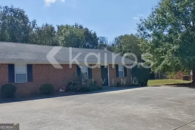 a front view of a house with a yard and trees