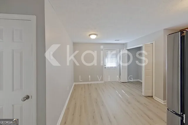 a view of a room with wooden floor and white walls