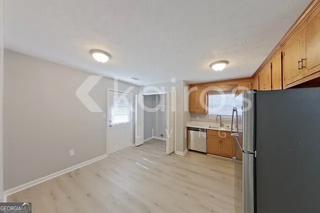 a kitchen with granite countertop a refrigerator stove top oven and sink