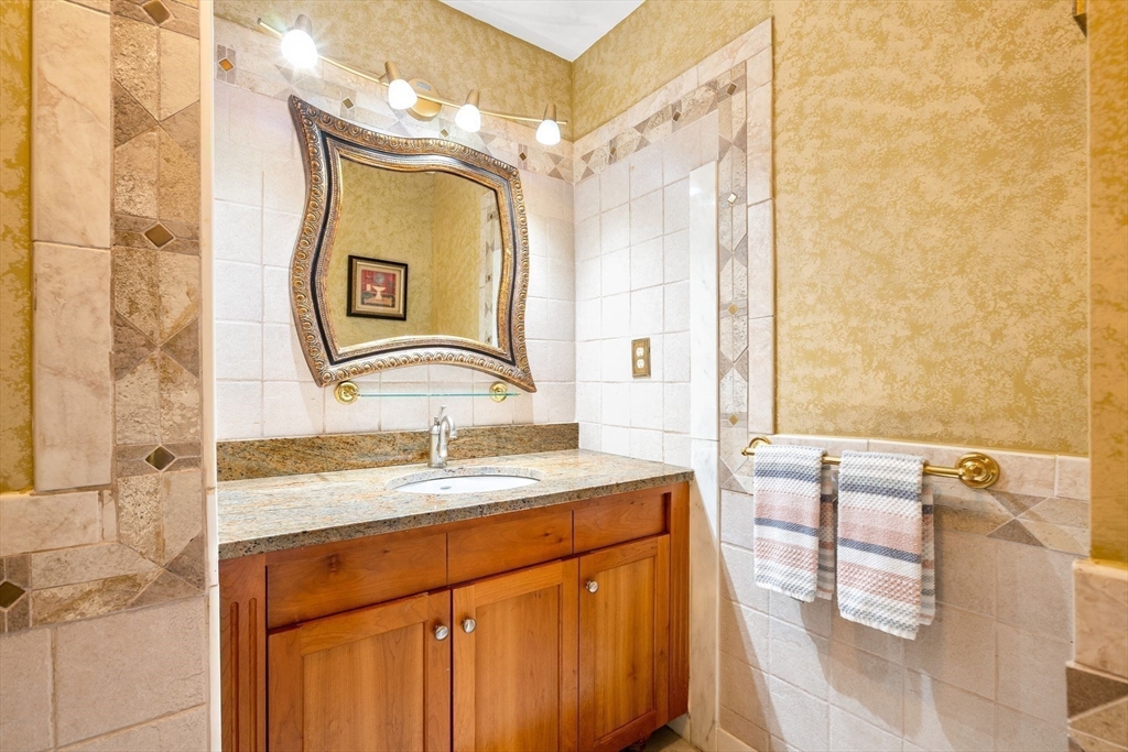 4 Rockland Terrace Saugus, MA 01906 - Photo 13 of 42 a bathroom with a granite countertop sink and a mirror