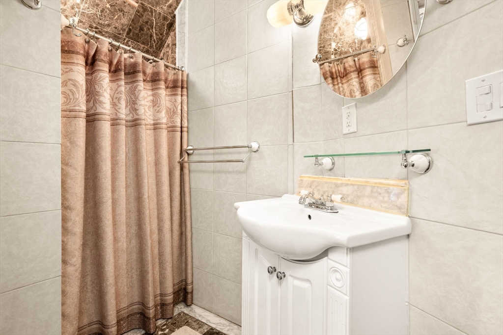 4 Rockland Terrace Saugus, MA 01906 - Photo 14 of 42 a bathroom with a sink a mirror and a shower