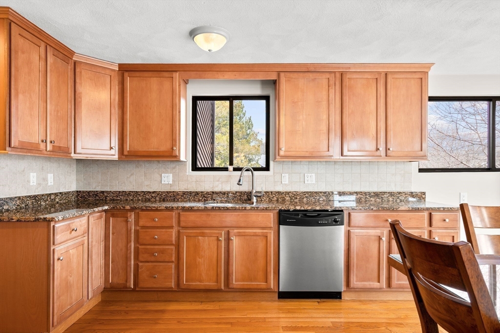 4 Rockland Terrace Saugus, MA 01906 - Photo 7 of 42 a kitchen with stainless steel appliances granite countertop wooden cabinets a microwave a stove and a sink