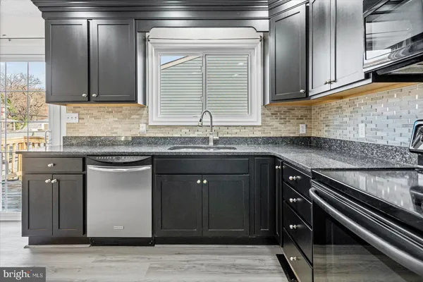 a kitchen with granite countertop a sink cabinets and window