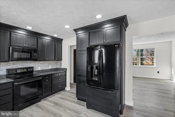 a kitchen with stainless steel appliances granite countertop a refrigerator and a stove