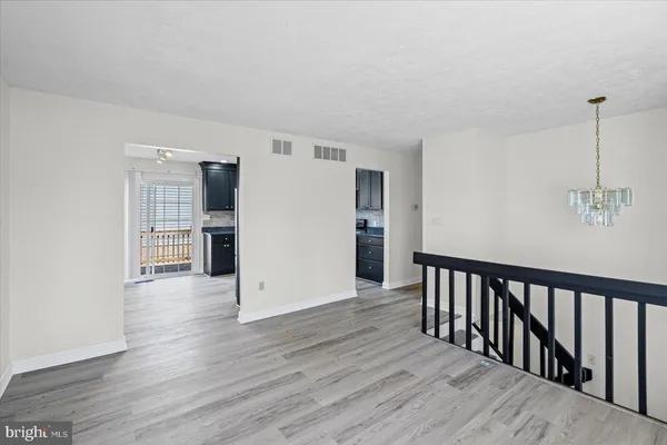 a view of a hallway with wooden floor and entryway