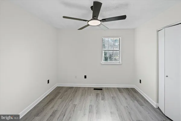 an empty room with a window and a ceiling fan