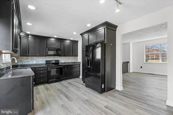 a kitchen with stainless steel appliances granite countertop a refrigerator and a sink