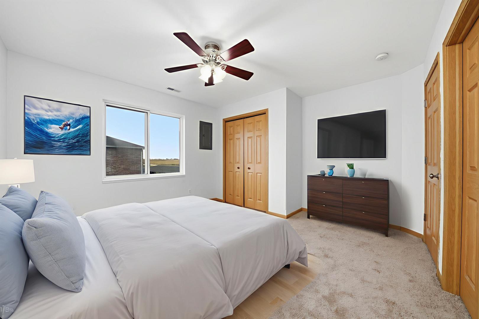 575 North Strack Street, Unit 302 Cortland, IL 60112 - Photo 8 of 11 a spacious bedroom with a bed and a flat screen tv