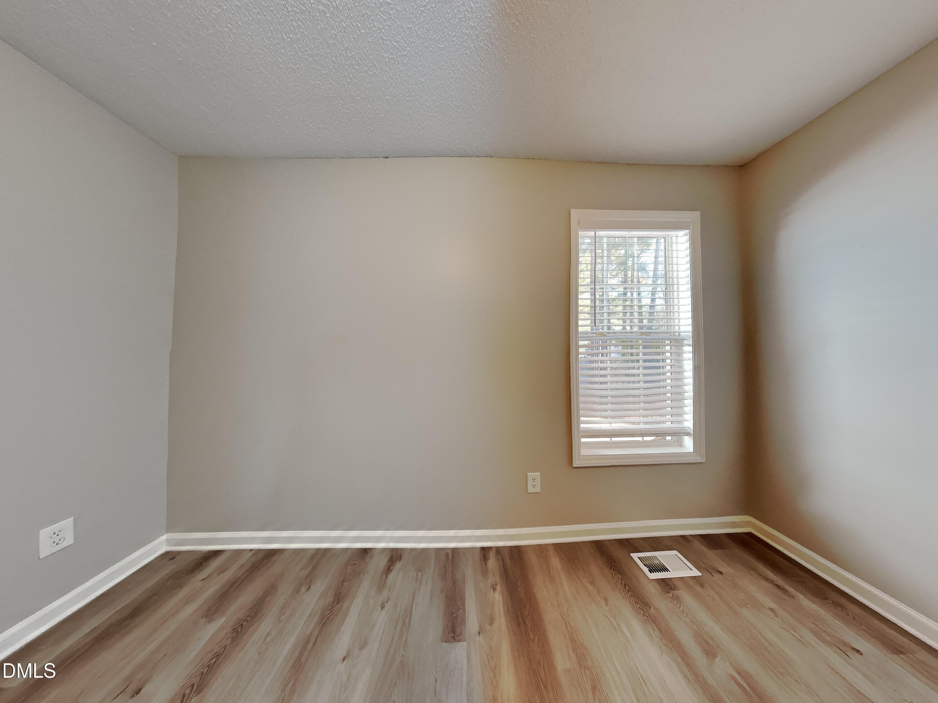2028 Ballston Place Knightdale, NC 27545 - Photo 12 of 15 an empty room with wooden floor and windows