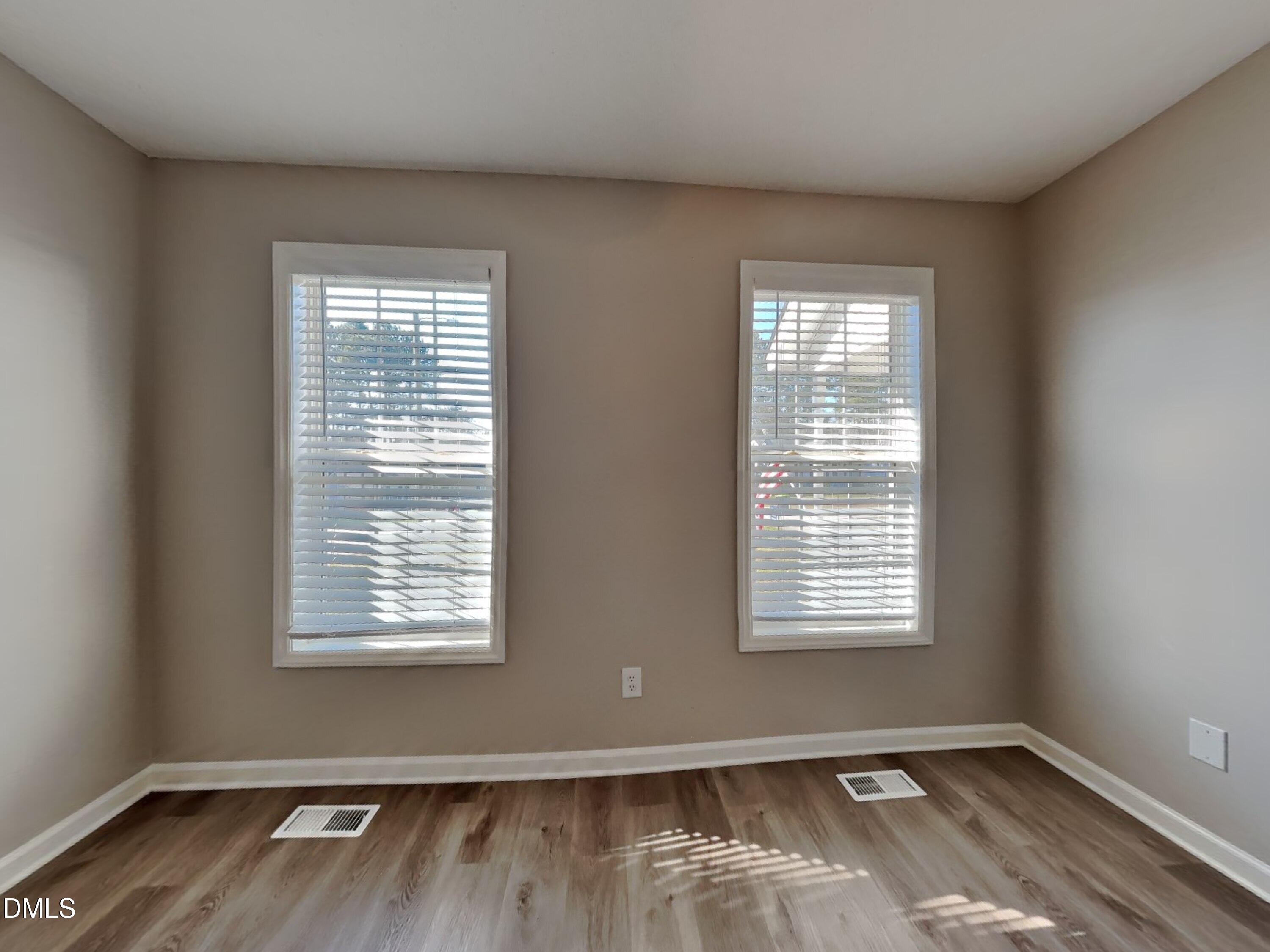 2028 Ballston Place Knightdale, NC 27545 - Photo 7 of 15 a view of an empty room with wooden floor and a window