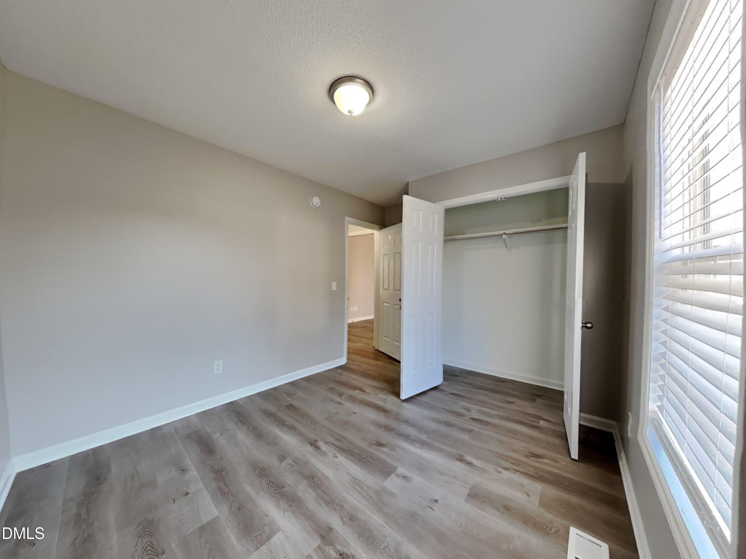 2028 Ballston Place Knightdale, NC 27545 - Photo 10 of 15 an empty room with wooden floor and windows