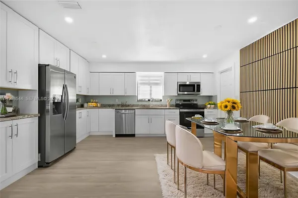 a kitchen with stainless steel appliances granite countertop a refrigerator stove microwave and sink