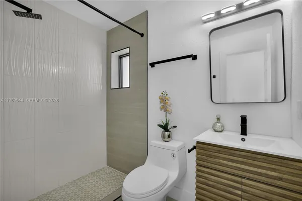 a bathroom with a toilet a sink and mirror