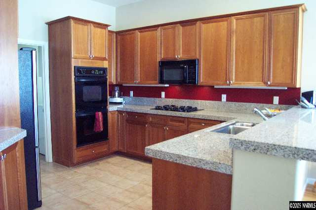 1815 Caughlin Creek Road Reno, NV 89519 - Photo 3 of 9 a kitchen with stainless steel appliances granite countertop a stove a sink and a microwave