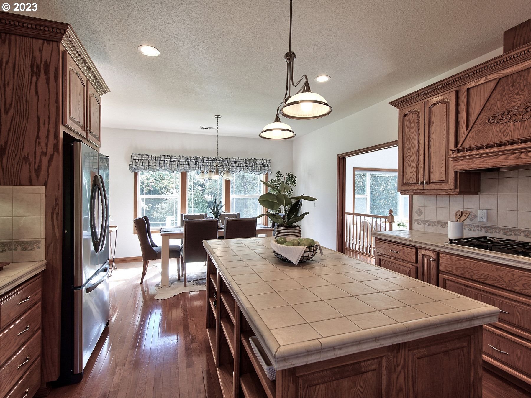 1101 Northeast 264th Street Ridgefield, WA 98642 - Photo 12 of 48 a kitchen with stainless steel appliances granite countertop a stove a refrigerator a kitchen island a dining table and chairs with wooden floor