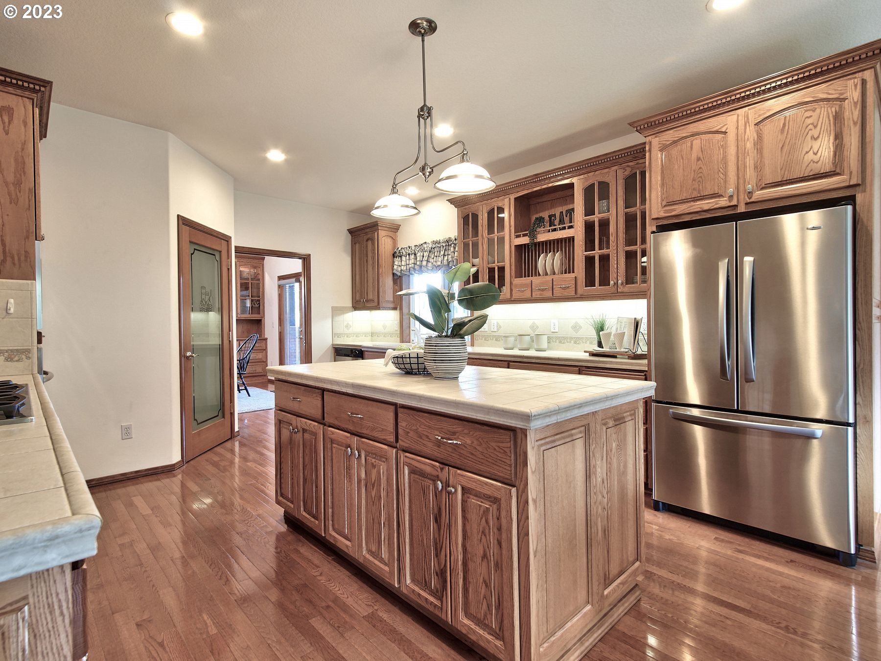 1101 Northeast 264th Street Ridgefield, WA 98642 - Photo 9 of 48 a kitchen with stainless steel appliances granite countertop a refrigerator a sink dishwasher a stove and a dining table with wooden floor