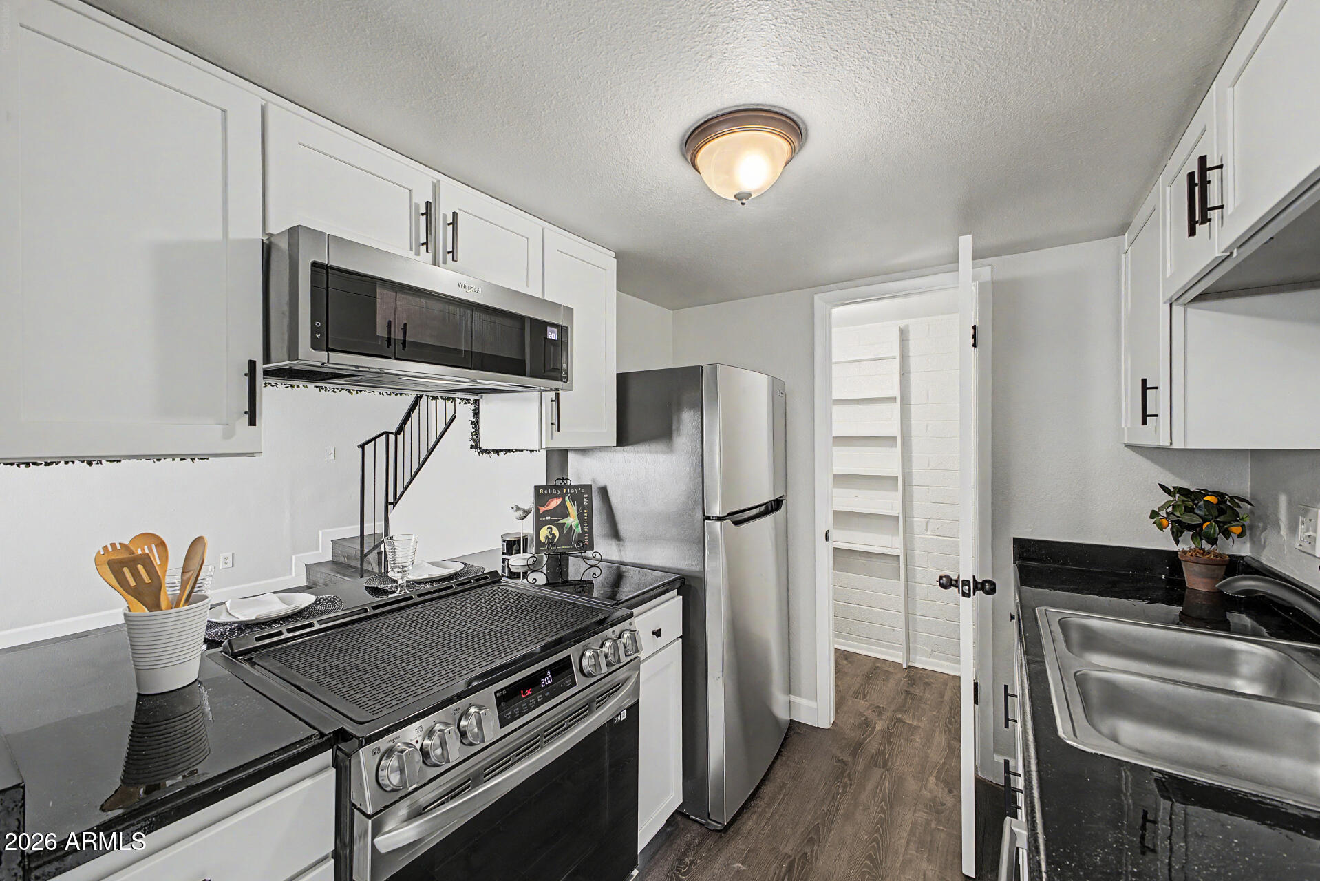 a kitchen with stainless steel appliances a stove a sink and a refrigerator