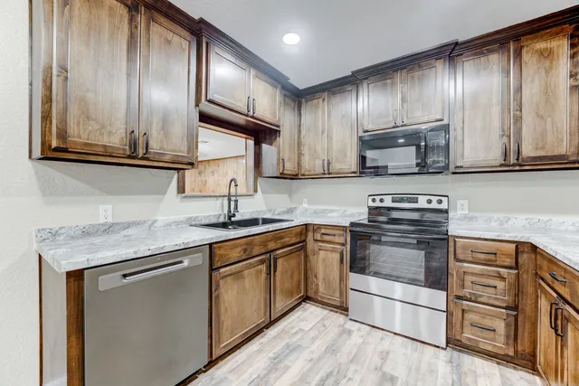 a kitchen with stainless steel appliances granite countertop a sink stove microwave and cabinets