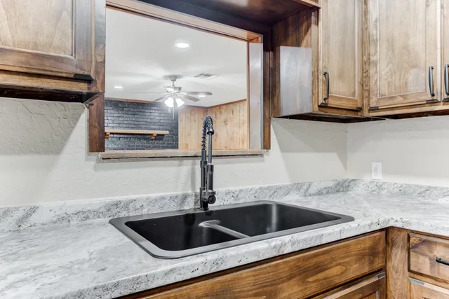 a kitchen with granite countertop a sink and a stove