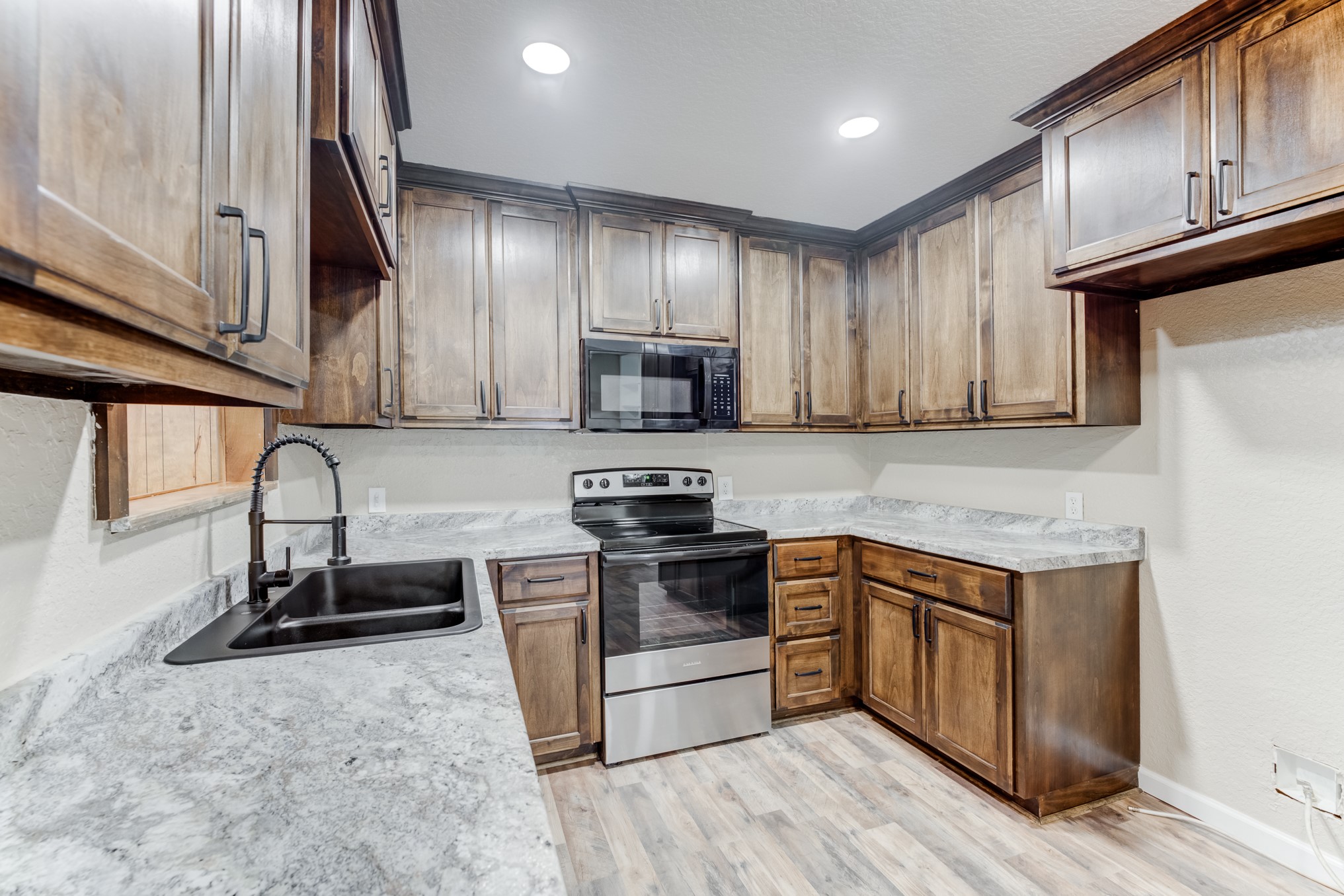 305 Yaupon Street Sweeny, TX 77480 - Photo 22 of 50 a kitchen with stainless steel appliances granite countertop wooden cabinets a stove top oven a sink and dishwasher