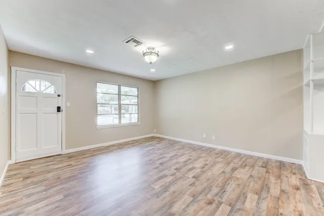 wooden floor in an empty room with a window