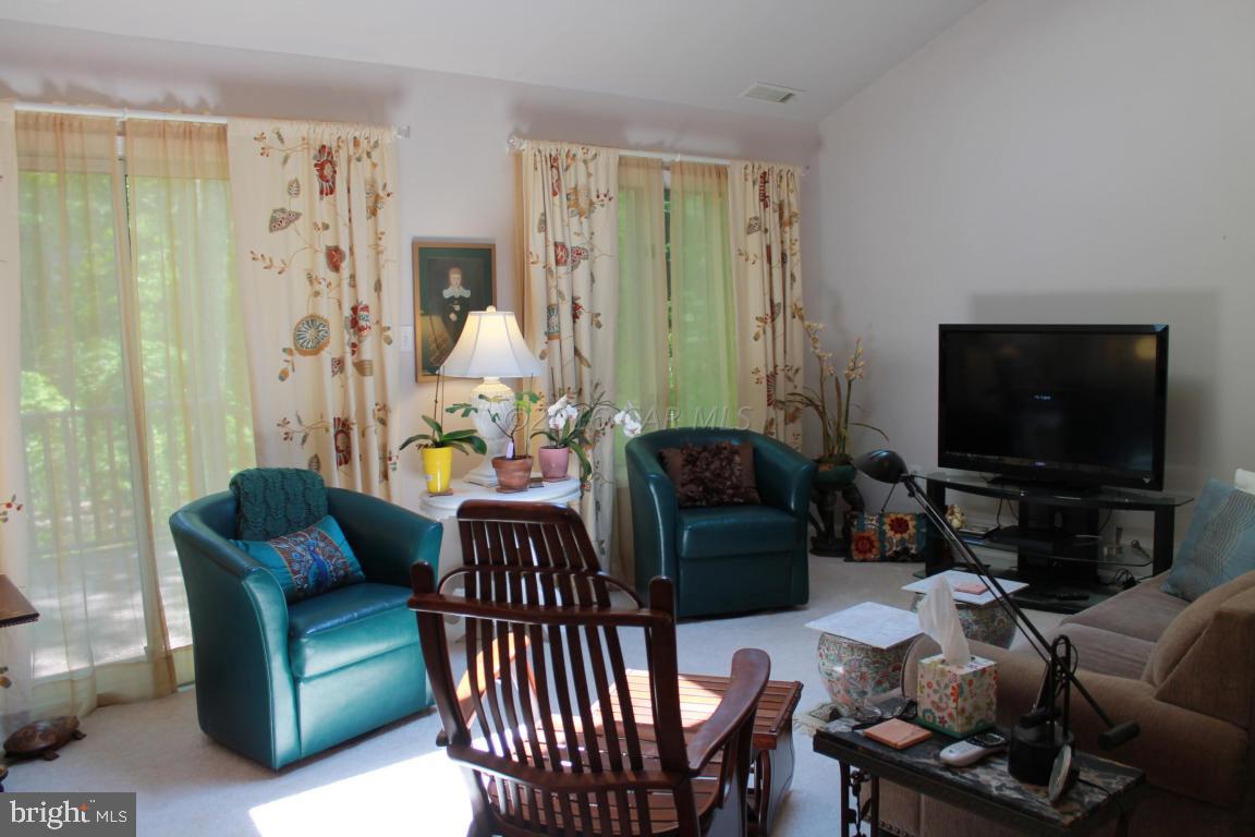 49 Moonraker Road Ocean Pines, MD 21811 - Photo 4 of 27 a living room with furniture a flat screen tv and a large window