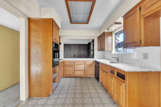 a kitchen with granite countertop a refrigerator and a stove top oven