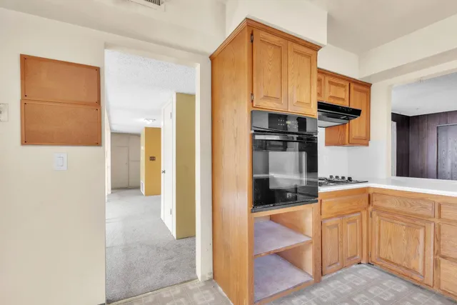 a view of an empty room with a fireplace and a window