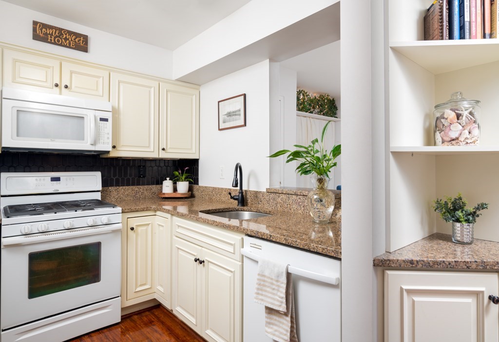 26 School Street, Unit 211 Hull, MA 02045 - Photo 8 of 19 a kitchen with granite countertop a stove a sink and a microwave