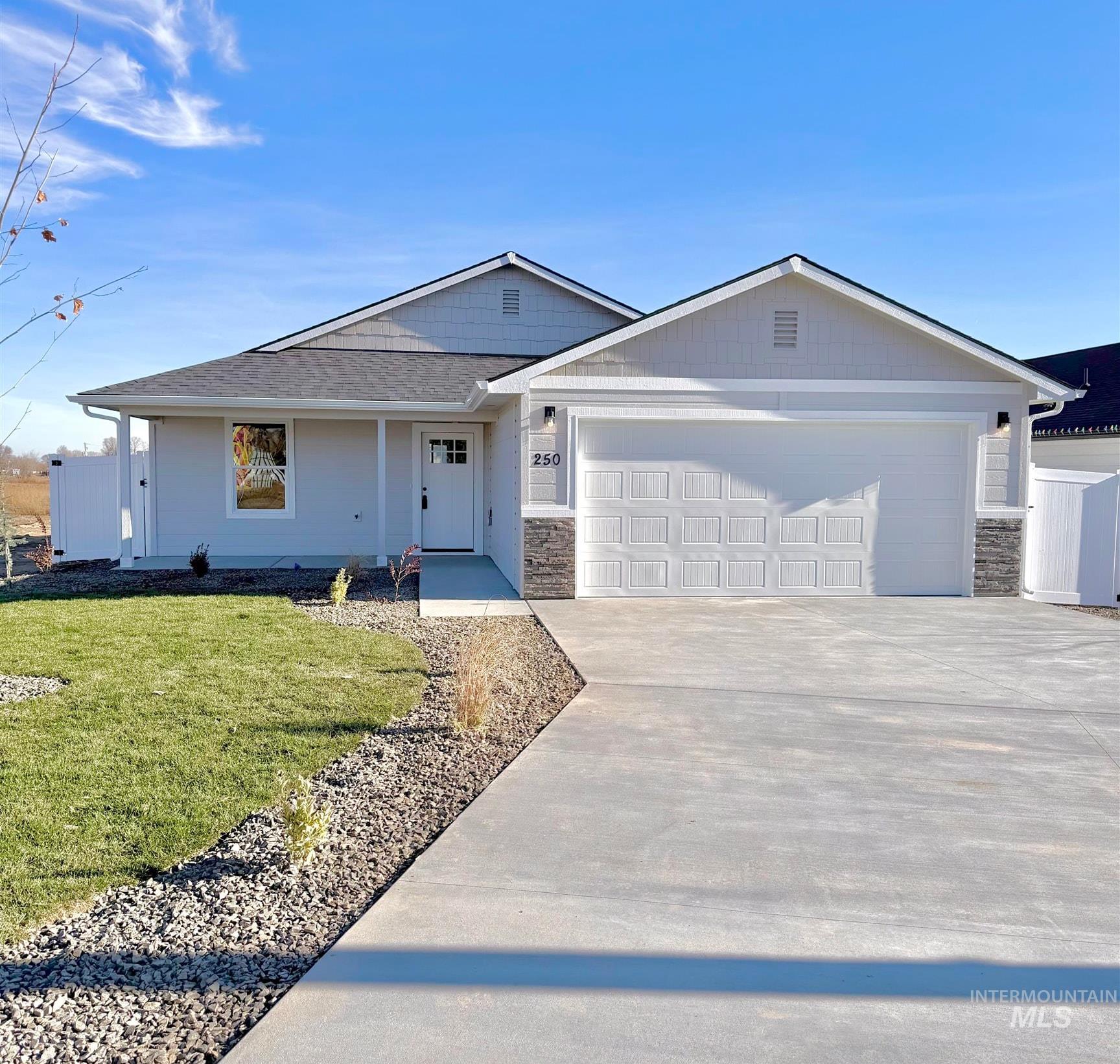 Ranch-style home with stone siding, concrete driveway, a garage, and covered porch