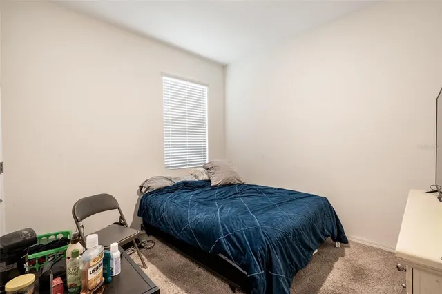 a bedroom with a bed and two windows