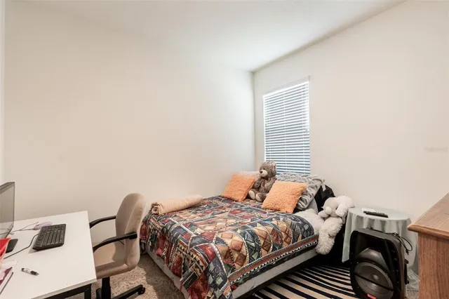 a bedroom with a bed and two windows