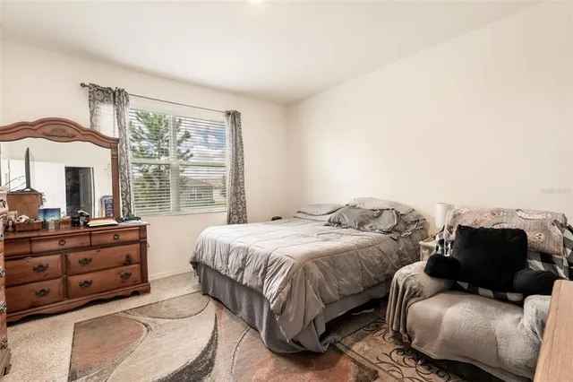 a bedroom with a bed and two large window