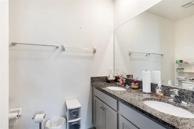 a bathroom with a granite countertop sink a toilet and a mirror