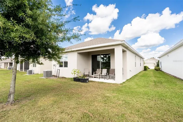 a view of a house with backyard and a tree