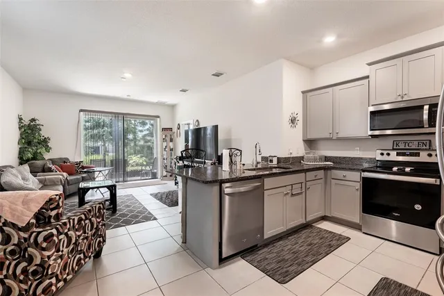 a kitchen with stainless steel appliances kitchen island granite countertop a sink and cabinets