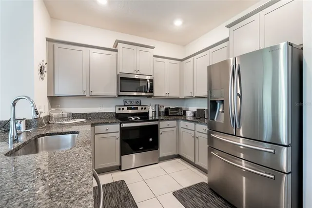 a kitchen with stainless steel appliances granite countertop a refrigerator stove and sink