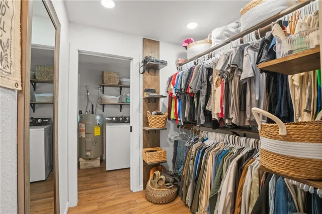a view of walk in closet with clothes and shoes