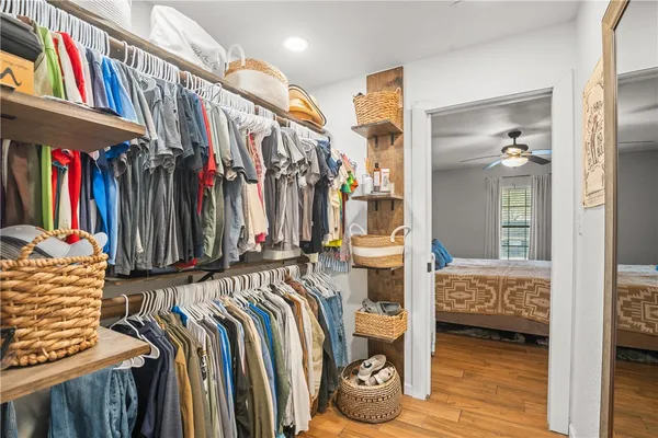 a view of walk in closet with clothes and shoes