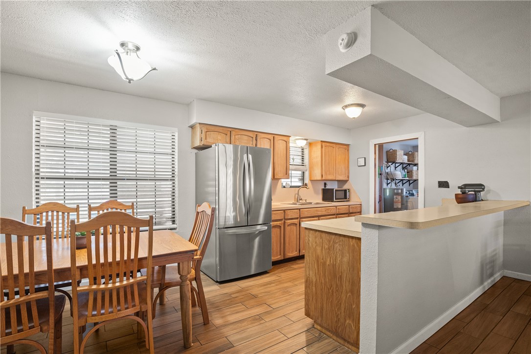 167 Trail Ridge Drive Sandia, TX 78383 - Photo 8 of 33 a kitchen with stainless steel appliances a stove a refrigerator a dining table and chairs with wooden floor
