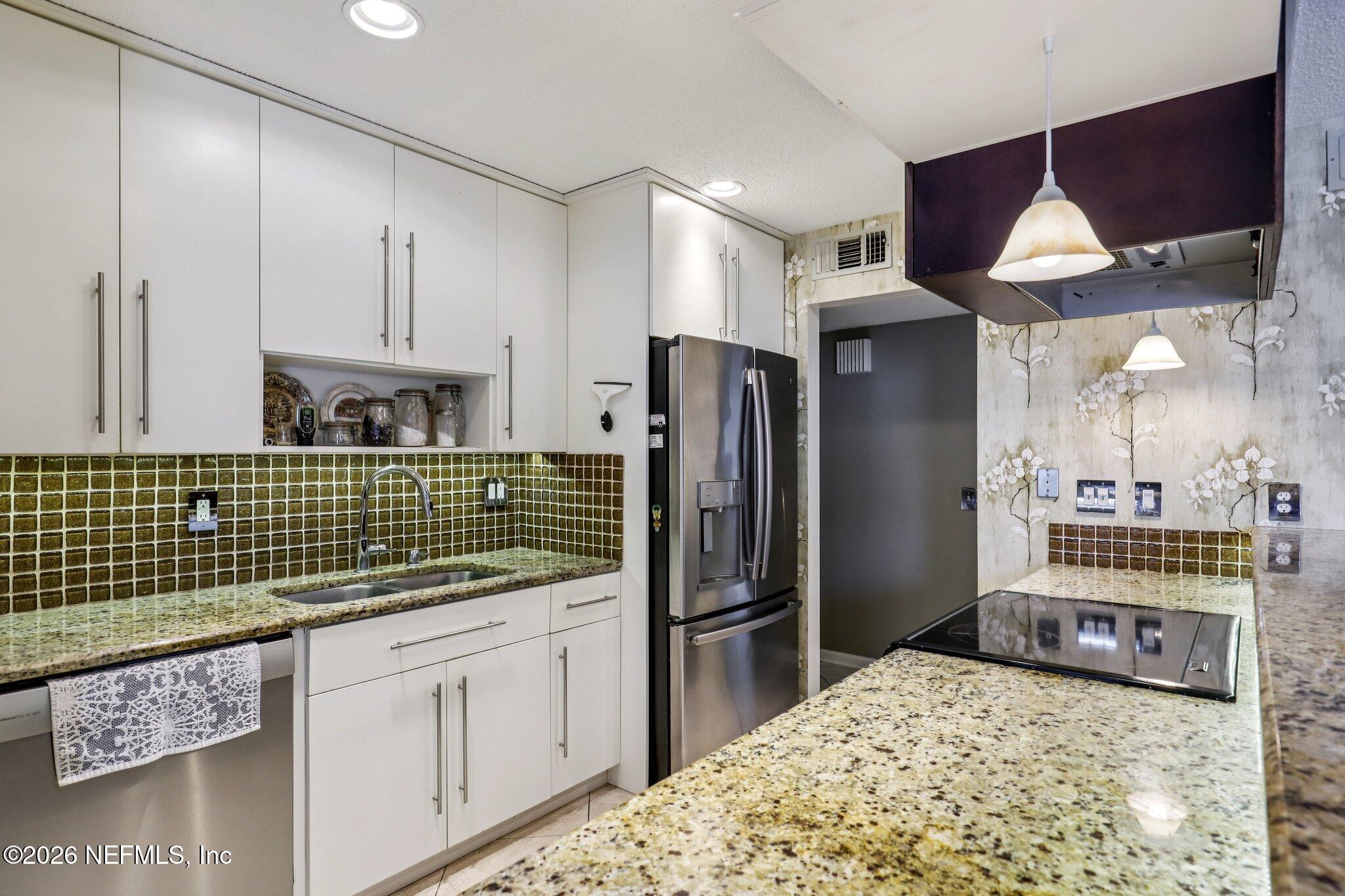 11654 Lake Ride Drive Jacksonville, FL 32223 - Photo 14 of 36 a kitchen with kitchen island granite countertop a refrigerator and a stove